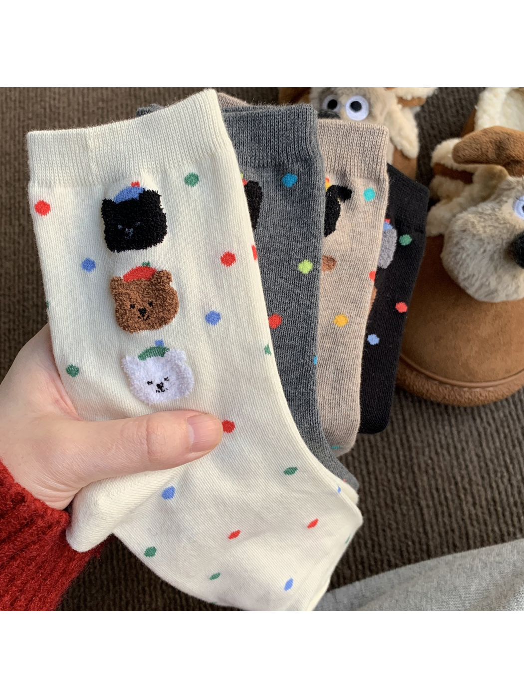 White, gray, oatmeal and black animal-face socks fanned together