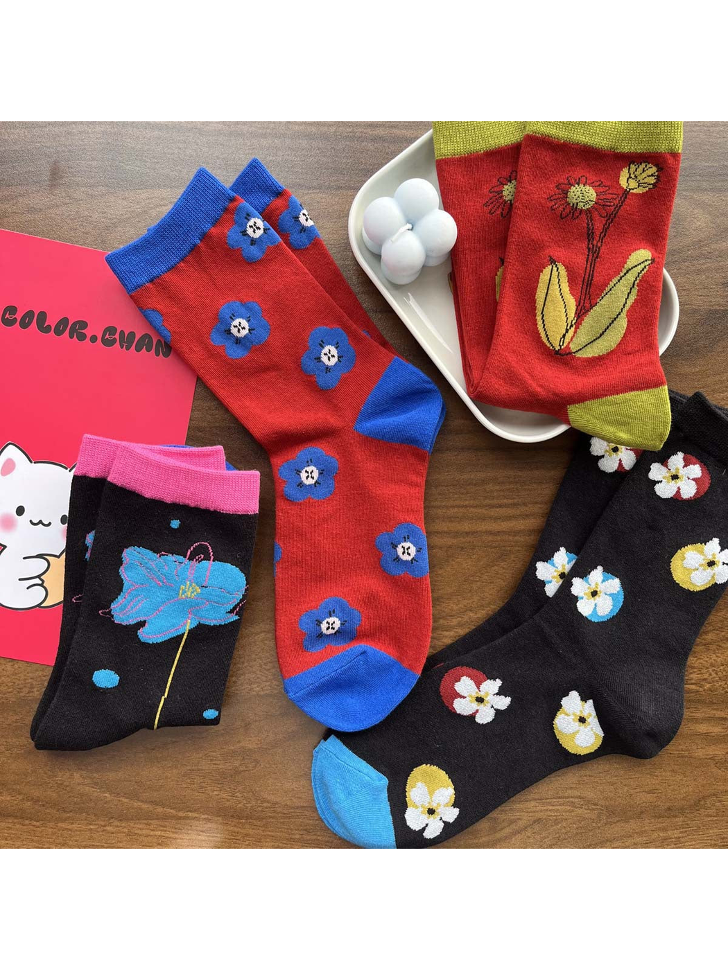 Four floral crew sock styles arranged with decorative props