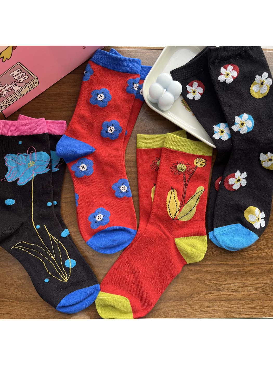 Floral crew socks arranged flat to show contrasting cuffs and toes