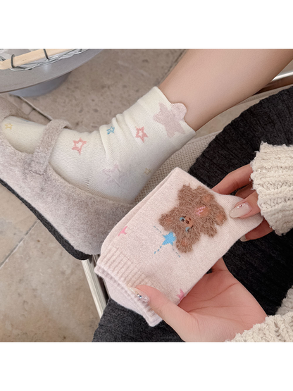 Moon Stars socks worn with fuzzy shoes beside folded Star Bear socks