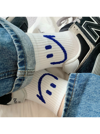 White smiley crew socks worn with jeans and black-and-white sneakers