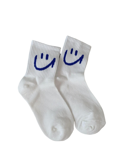 White crew socks with blue smiley motifs on a plain background
