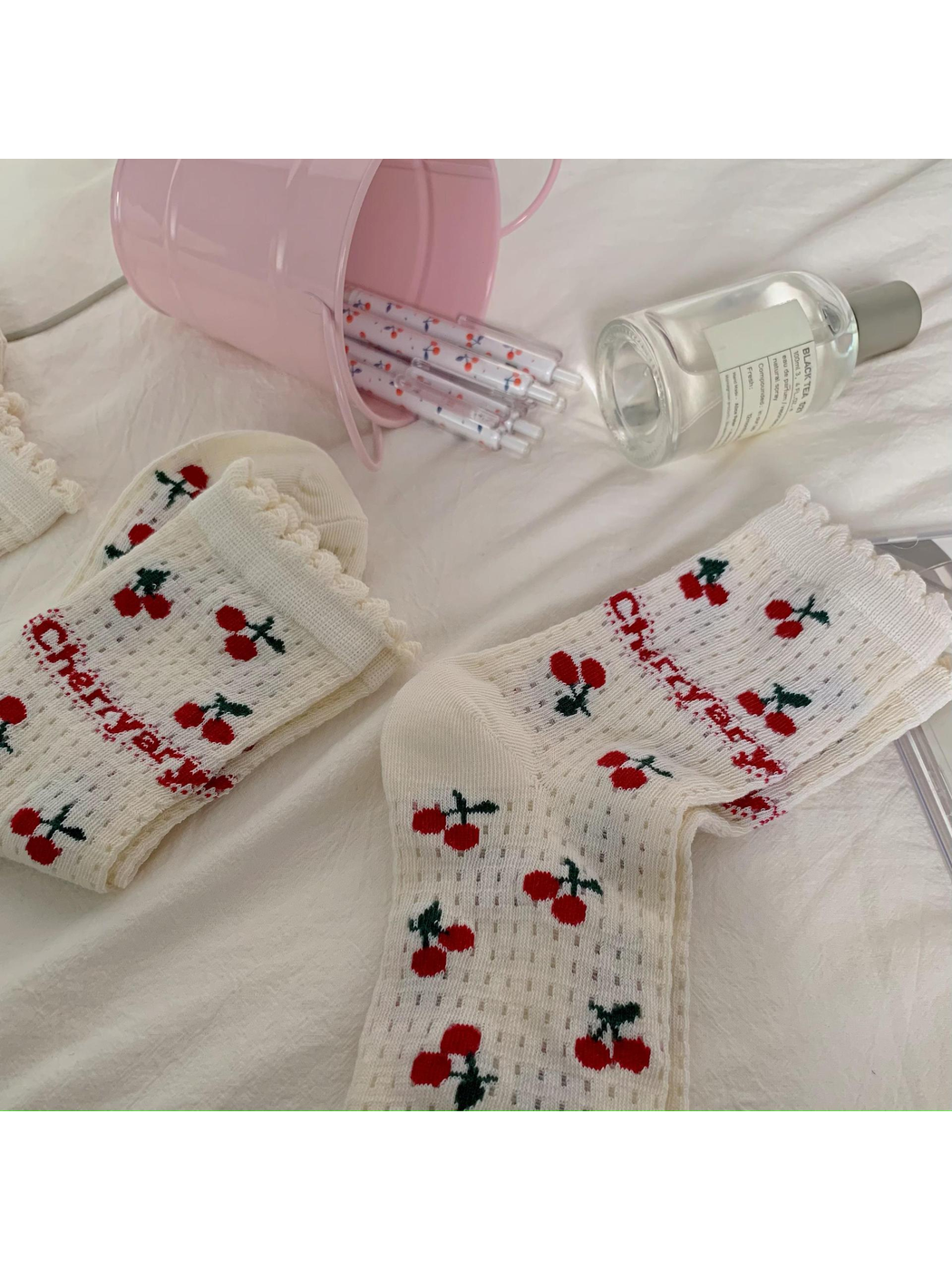 Ivory cherry-pattern socks showing openwork knit rows and ruffled cuffs