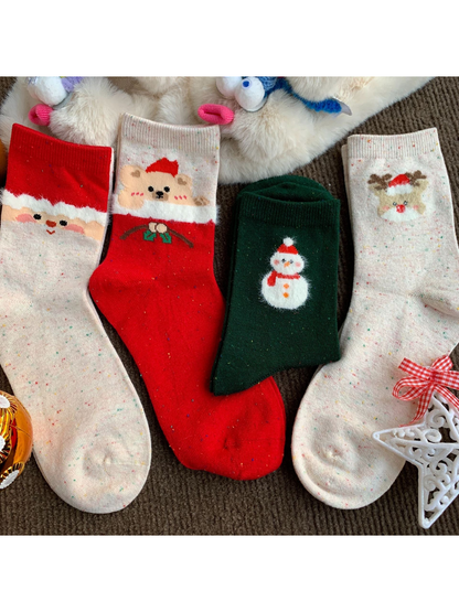 Four holiday crew sock styles arranged with plush winter props