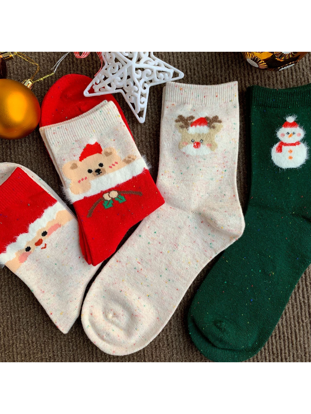 Bear, Reindeer, Santa and Snowman crew socks arranged with ornaments
