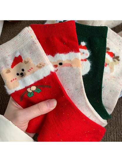 Close view of four holiday crew sock styles held in one hand
