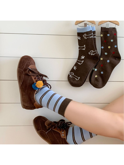 Light blue striped socks worn with brown shoes beside hanging dog outline and polka dot styles