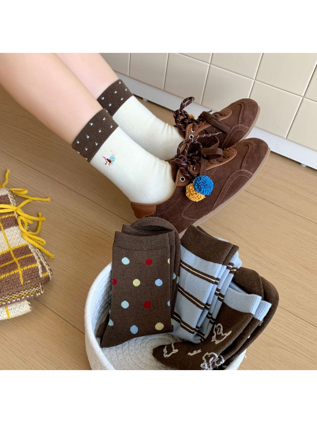 Ivory Dachshund socks worn with brown shoes beside a basket of assorted styles