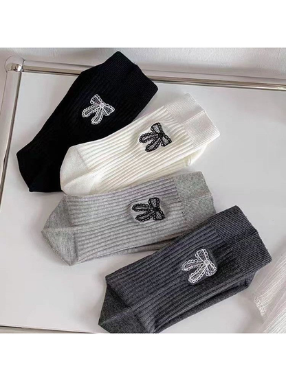 Four colors of ribbed socks with contrasting embroidered bow motifs