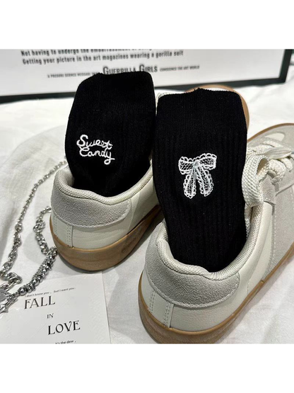 Black ribbed socks with white bow and script embroidery
