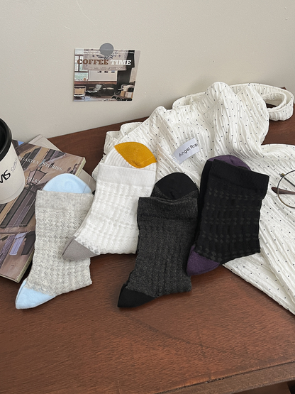 White, light gray, dark gray and black openwork crew socks displayed together
