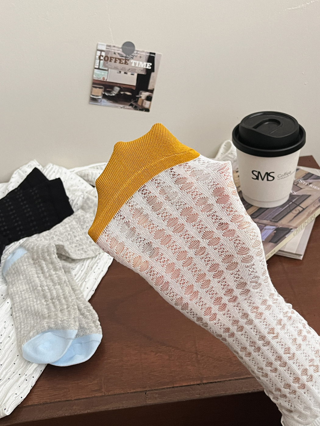 Close-up of a white openwork crew sock with a mustard-yellow heel