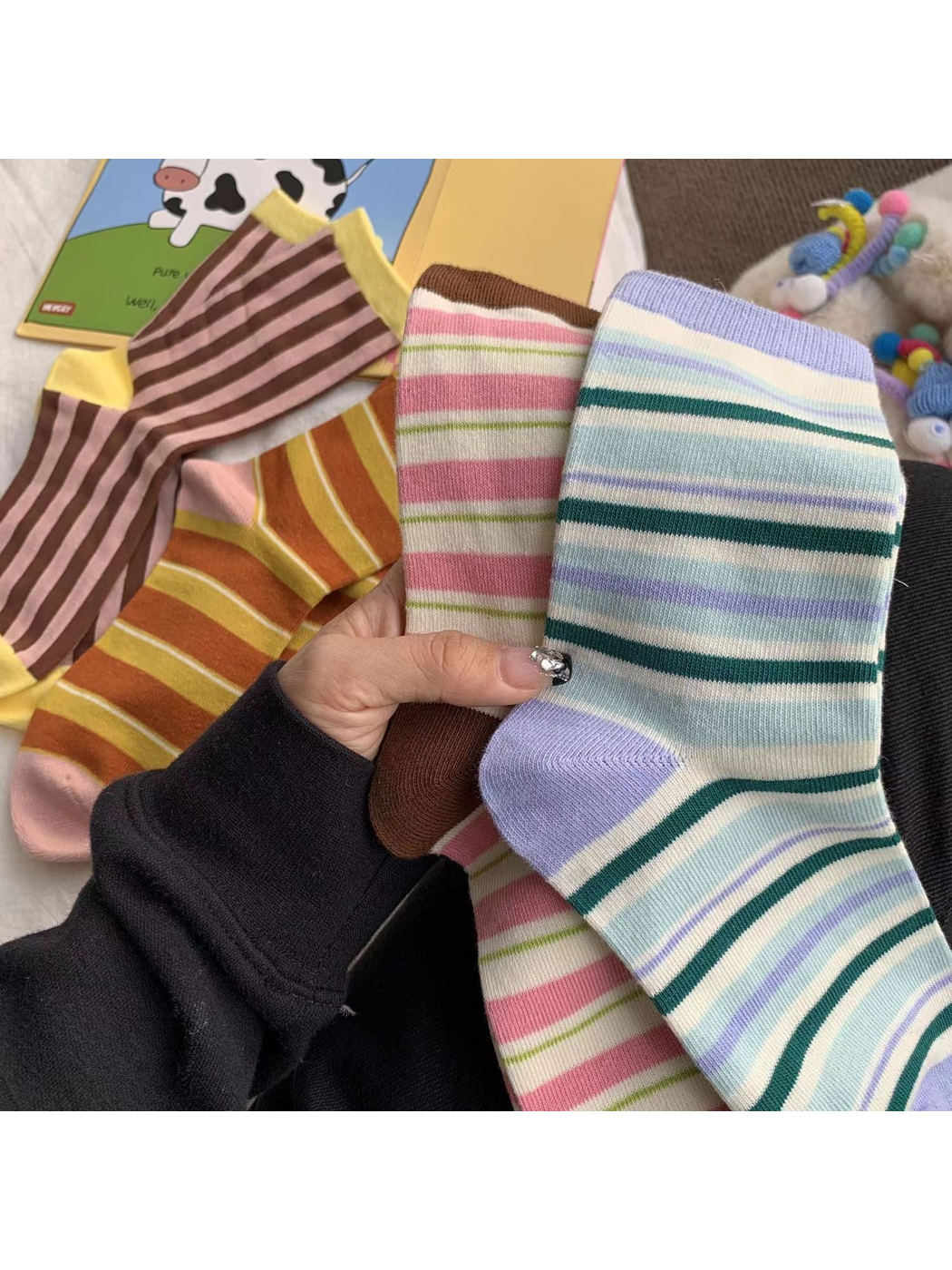 Blue and Pink striped socks held in front of the coordinating styles