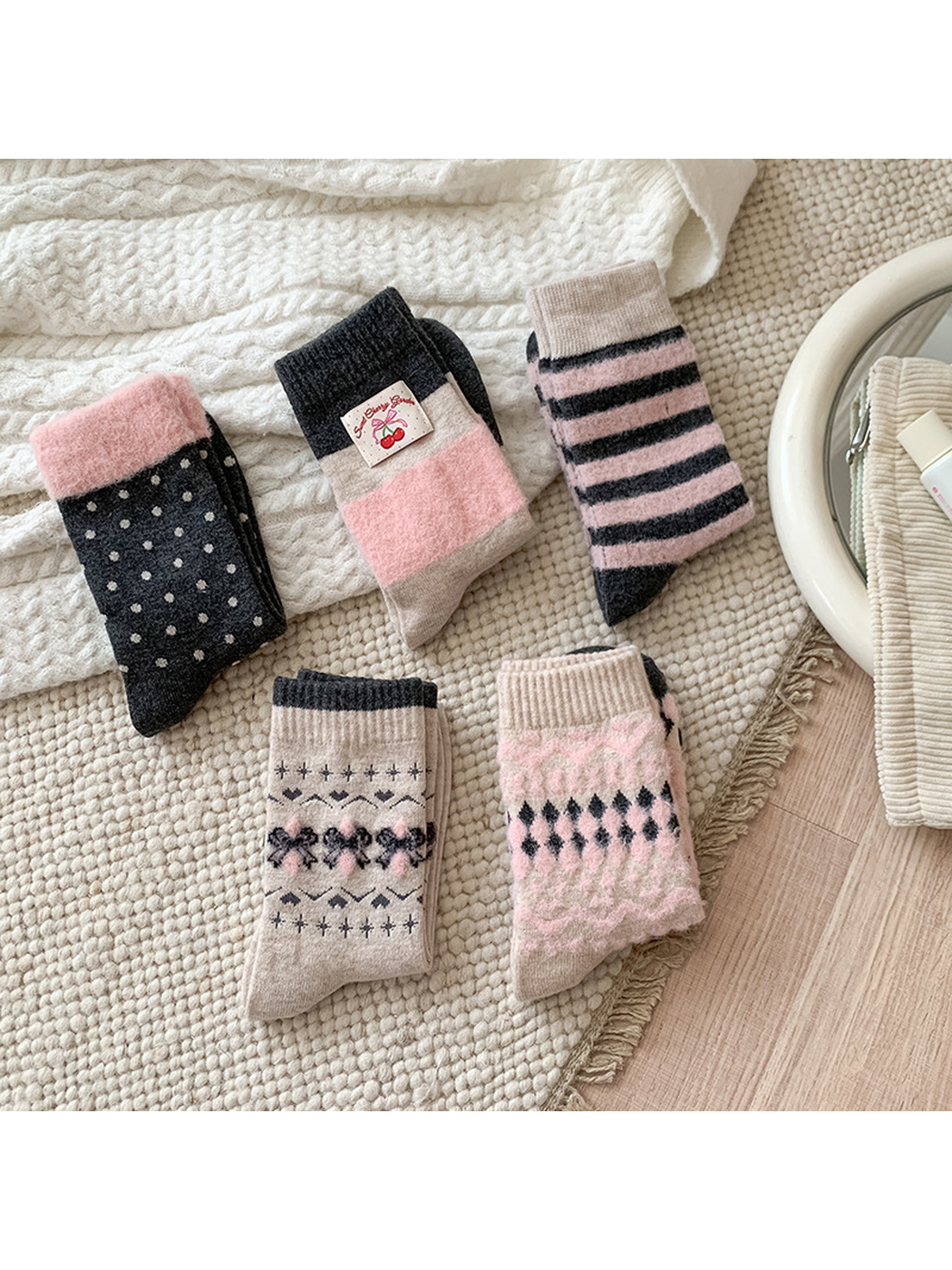 Five pink, charcoal and beige crew sock styles arranged together