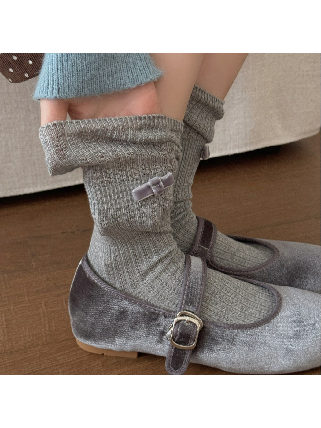 Light gray ribbed bow socks styled with gray Mary Jane shoes