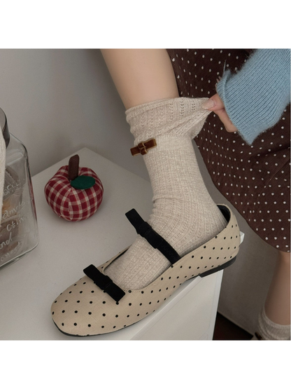 Beige ribbed bow sock styled with polka-dot Mary Jane shoes