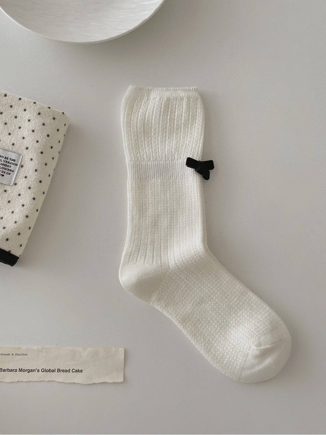 White ribbed crew sock with openwork cuff and black bow accent