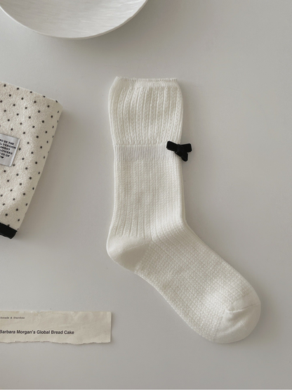 White ribbed crew sock with openwork cuff and black bow accent