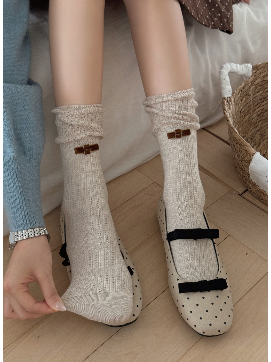 Beige ribbed bow socks worn with polka-dot Mary Jane shoes