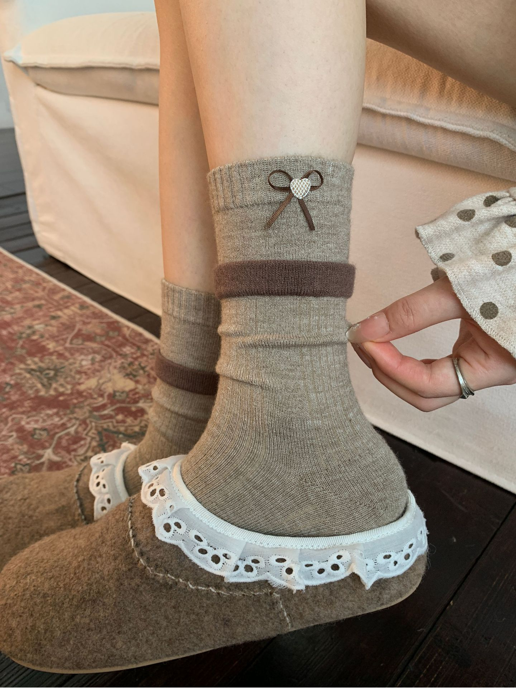 Heart style greige crew socks styled with lace-trimmed slippers