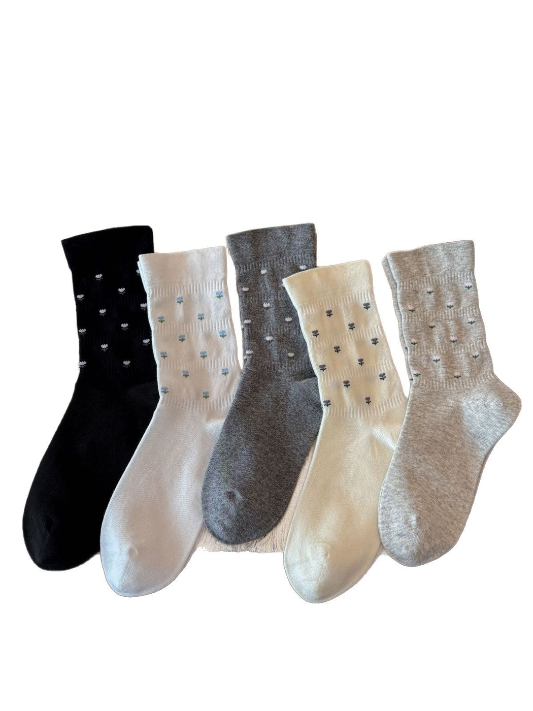 Five color variants of crew socks with miniature flower motifs displayed together