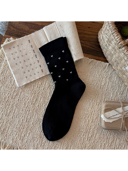Black crew sock with miniature white flower motifs, flat display