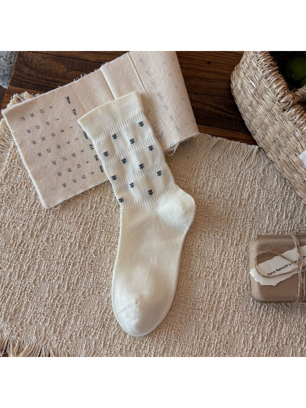 Ivory crew sock with miniature purple flower motifs, flat display