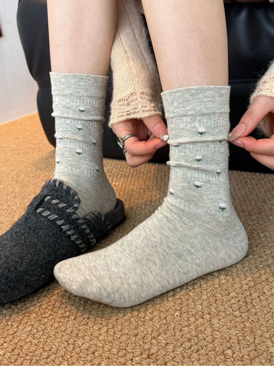 Light Gray crew socks with miniature pink flower motifs, worn front view