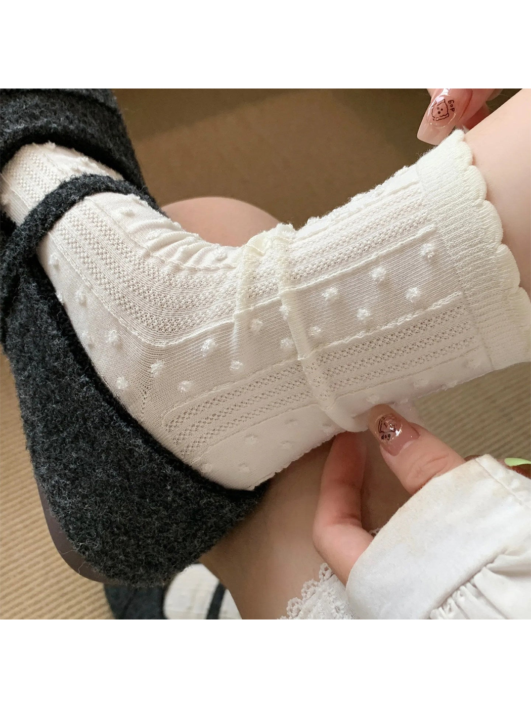 Close-up of Ivory socks with raised dots, pointelle panels and scalloped cuffs