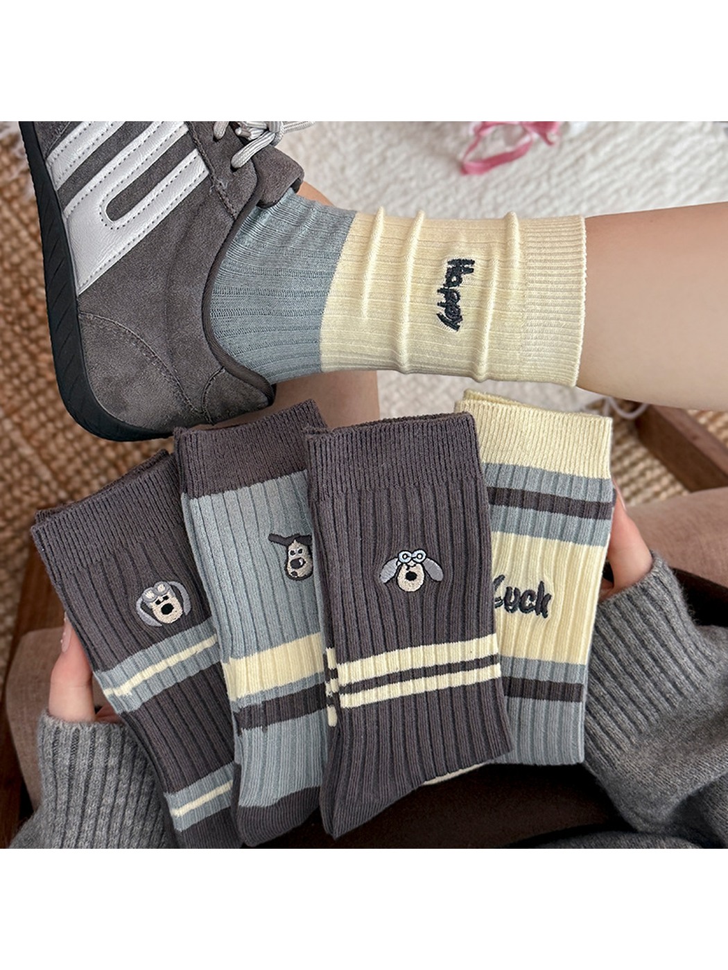 Multiple striped and embroidered crew sock styles displayed below a worn sock