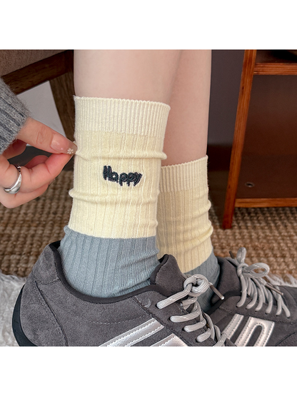 Close-up of a Happy style ribbed crew sock worn with a gray sneaker