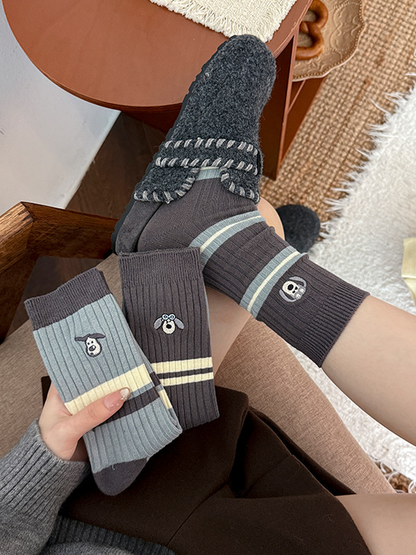 Three striped embroidered crew sock styles displayed in a casual setting