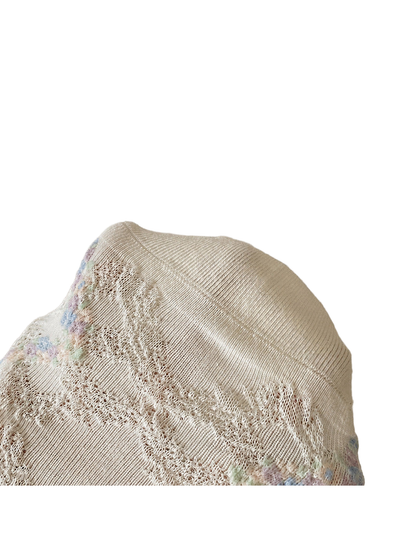 Close-up of an ivory sock toe seam and openwork diamond texture