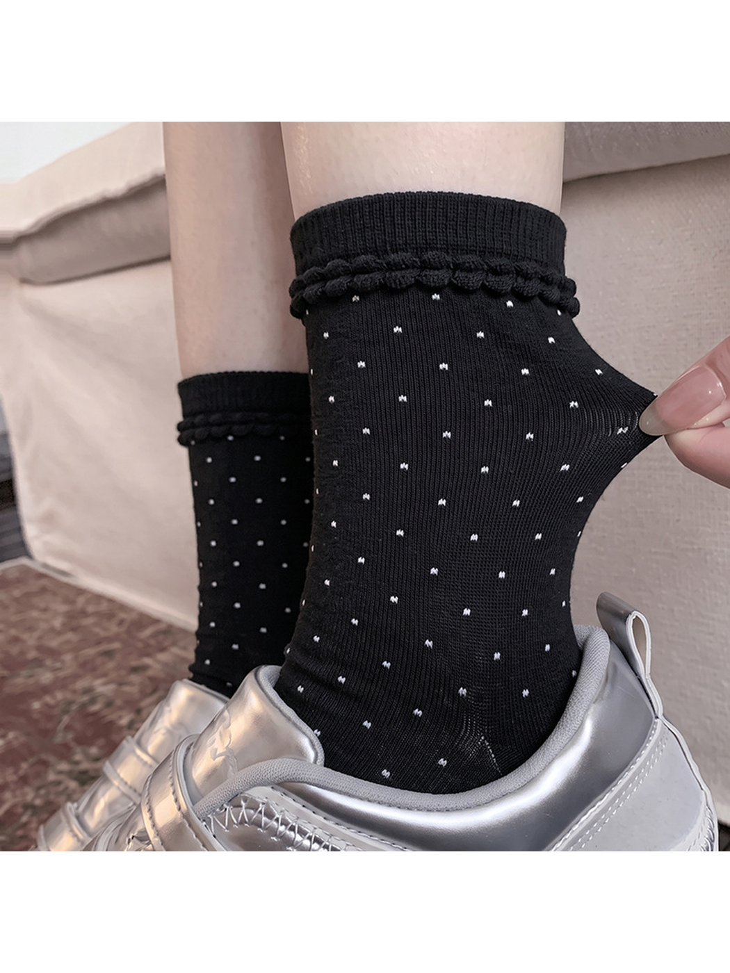 Close-up of a black polka-dot crew sock and looped cuff trim