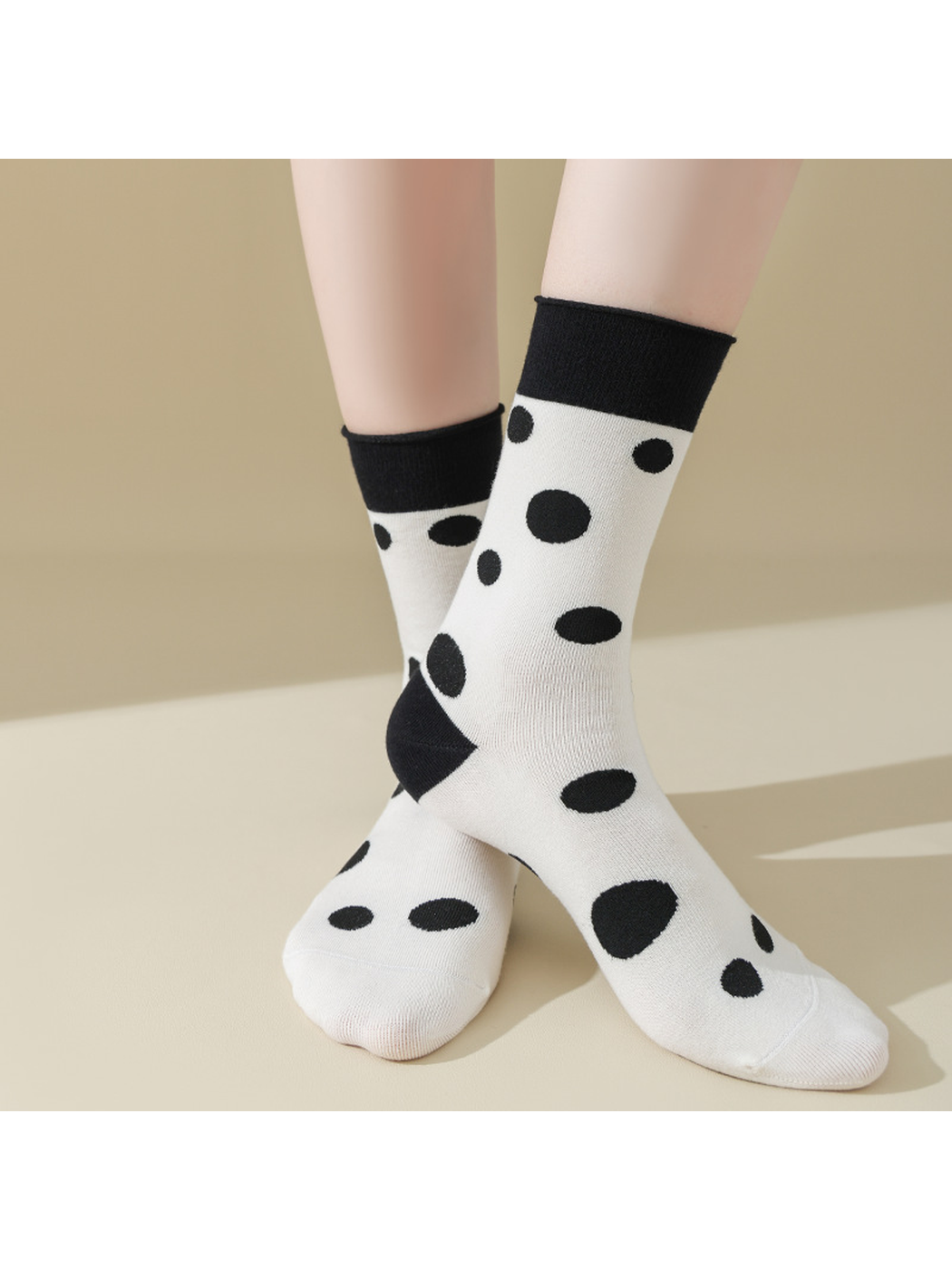 Black Dots socks worn with crossed ankles