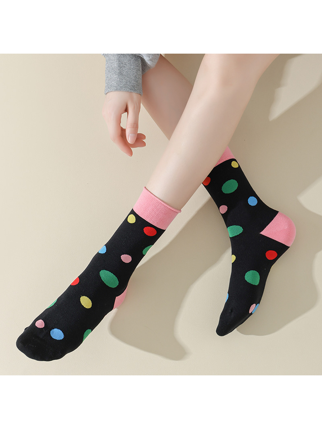 Pink Dots socks worn against a neutral background