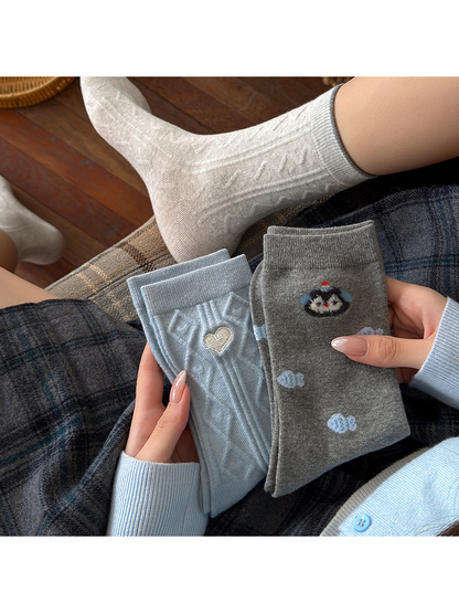 Waves socks worn with folded Heart and Fish styles held in hand