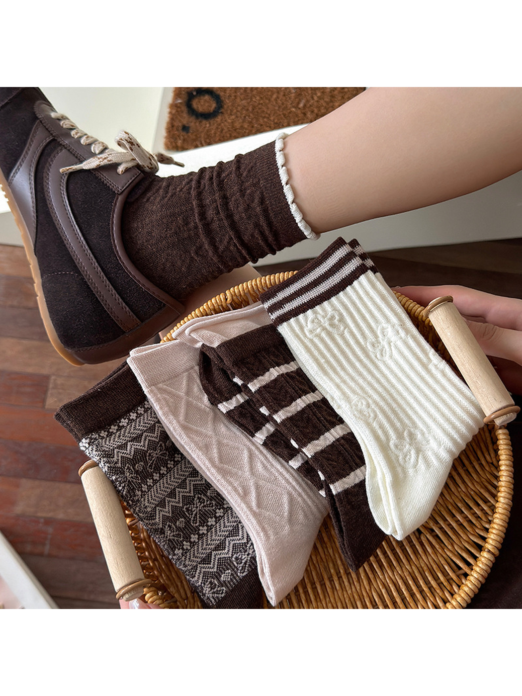 Brown Cable crew sock worn above a basket holding four other styles