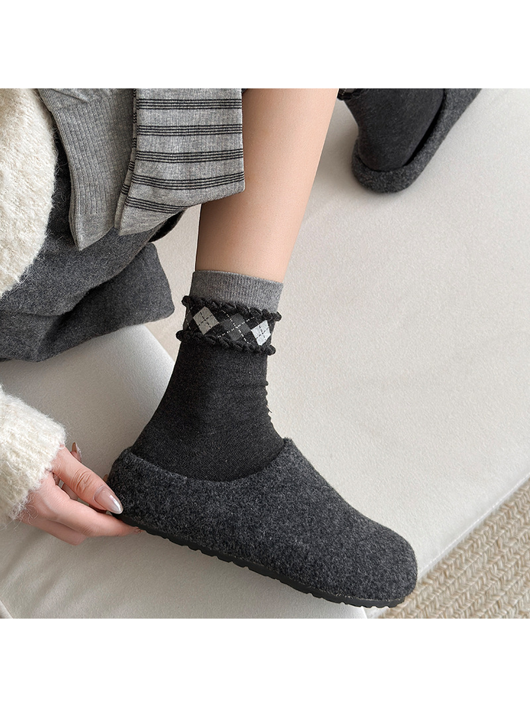 Argyle black and gray crew sock styled with a dark slipper