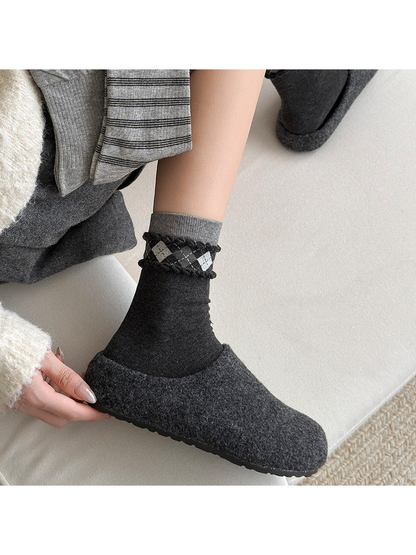 Argyle black and gray crew sock styled with a dark slipper