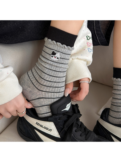 Striped Cat socks worn with black sneakers