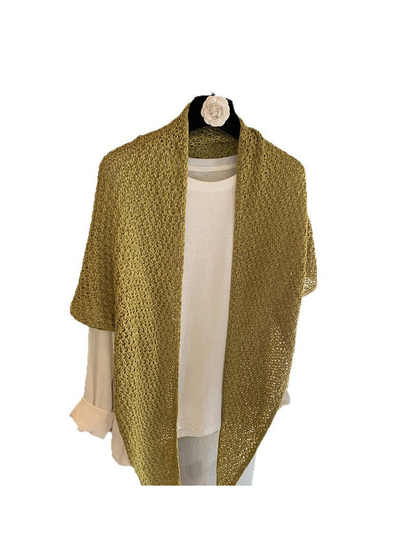 Green openwork triangle scarf draped over a white top on a hanger
