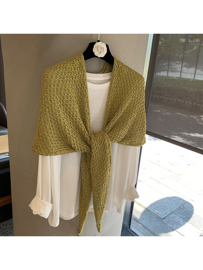 Green openwork triangle scarf tied over a white top