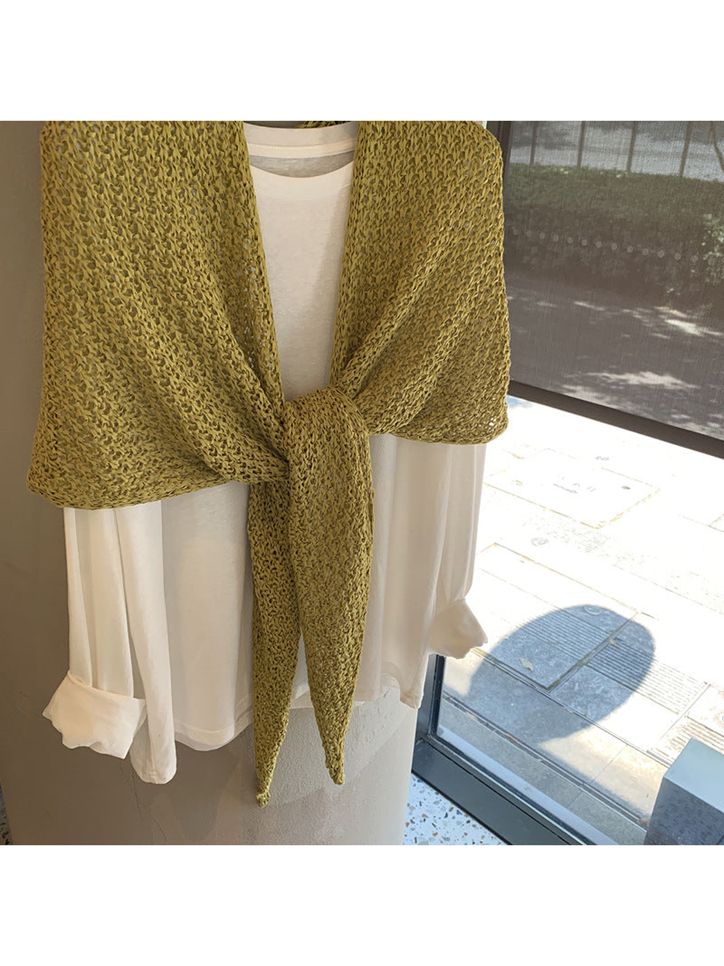 Close-up of the green openwork scarf texture and tied ends