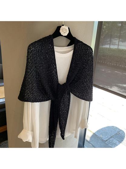 Black openwork triangle scarf tied over a white top