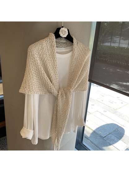 Beige openwork triangle scarf tied over a white top