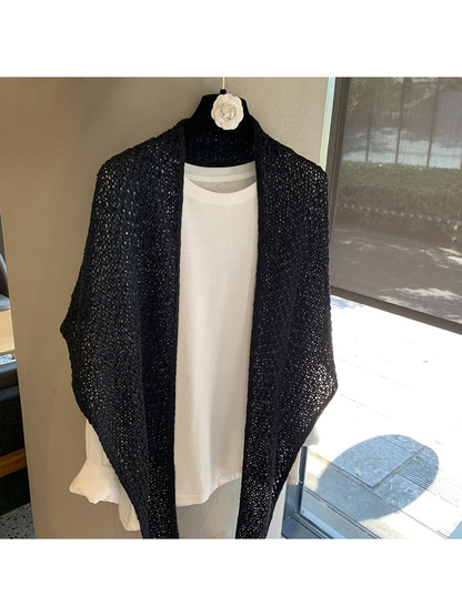 Black openwork triangle scarf draped loosely over a white top