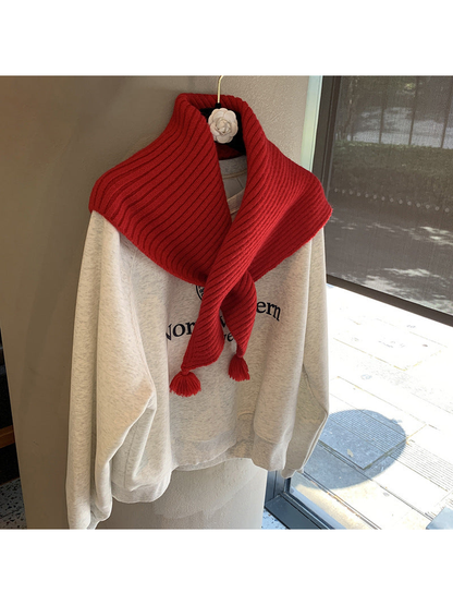 Red ribbed triangle scarf crossed at the front with tassel ends