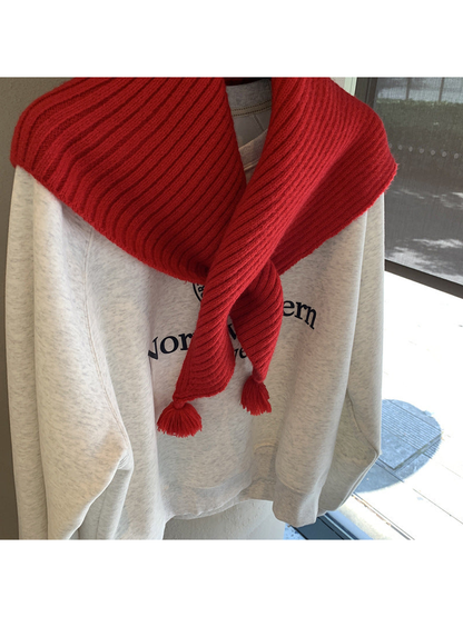 Close-up of the red triangle scarf's pointed ends and matching tassels