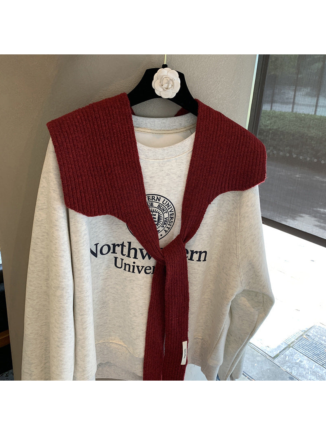 Burgundy ribbed shoulder scarf with the long ends loosely crossed